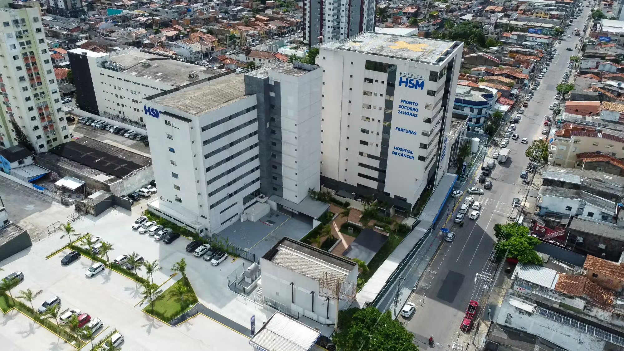 Vista aérea do complexo do Hospital HSM, com estacionamento e os dois prédios